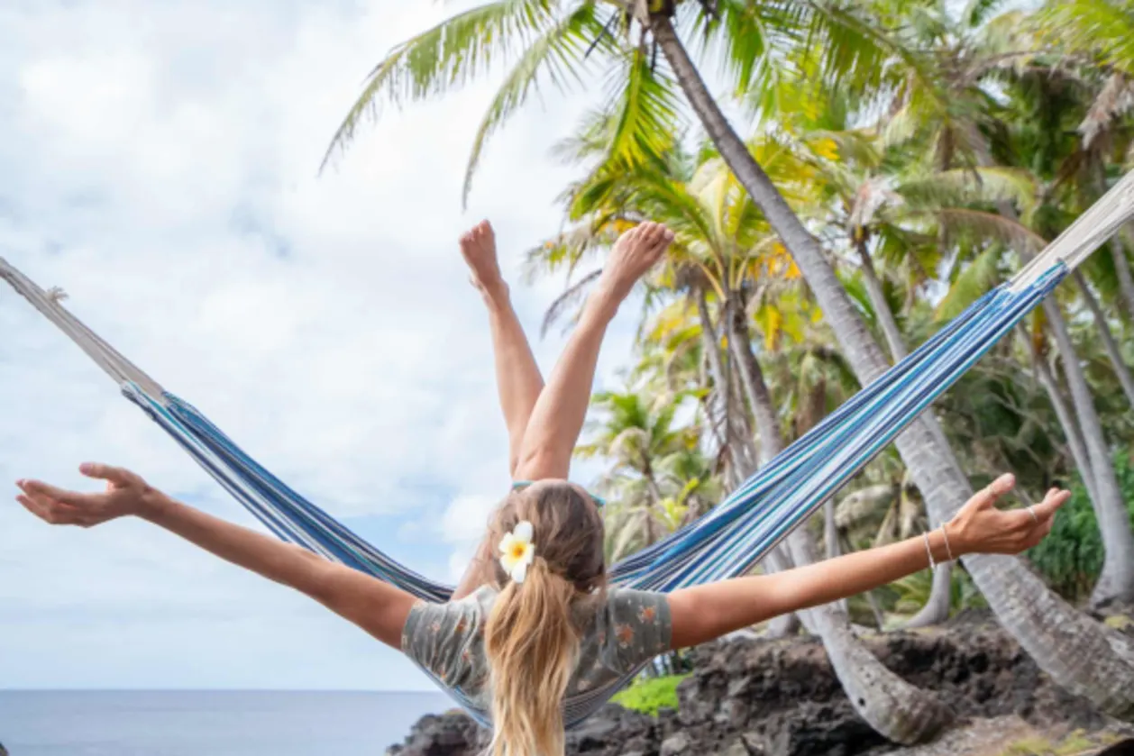 woman swinging on hammock on Hawaiian beach